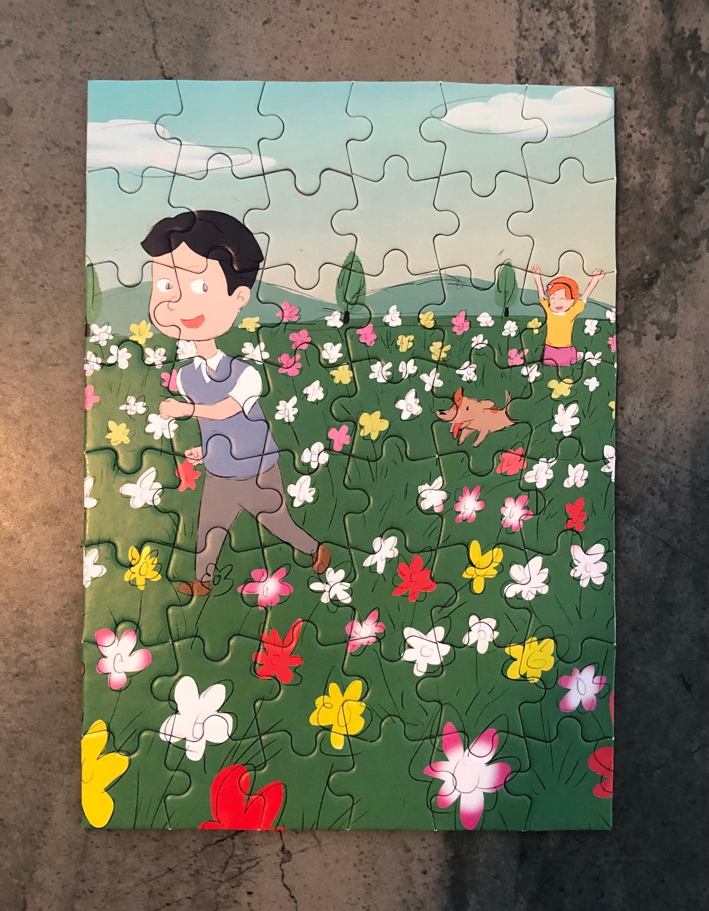 Children's jigsaw puzzle featuring kids playing in a flower field with a dog